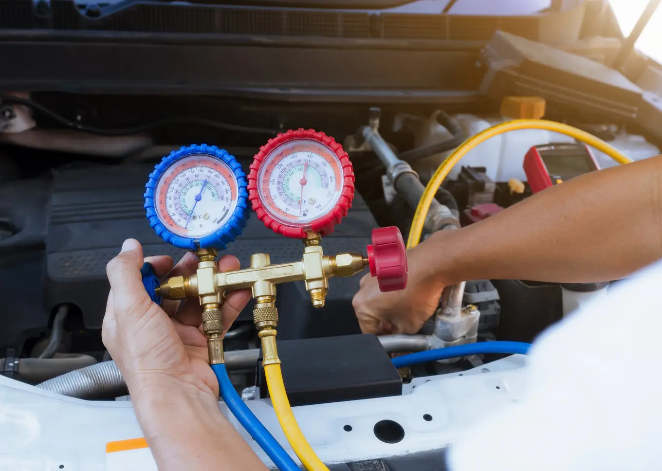 mechanik serwisujący klimatyzację samochodową